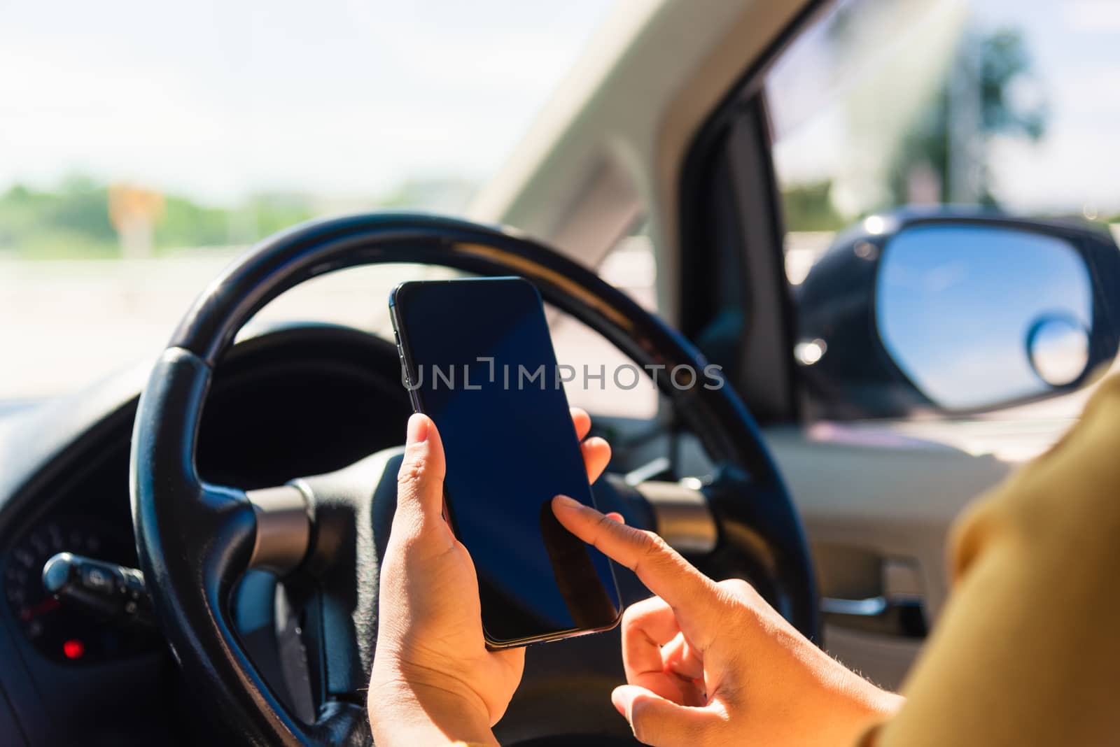 Asian woman inside a car and using touch screen on mobile smartphone blank screen while driving the car in the morning on highway she find navigation location to go Transportation and vehicle concept