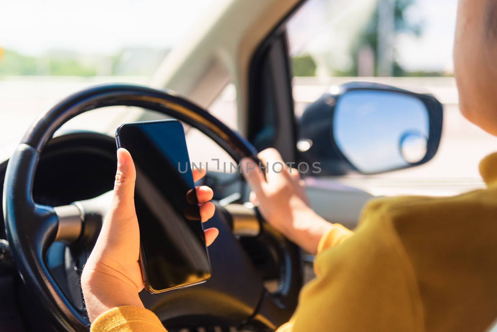 woman inside a car and using a hand holding mobile smartphone by Sorapop