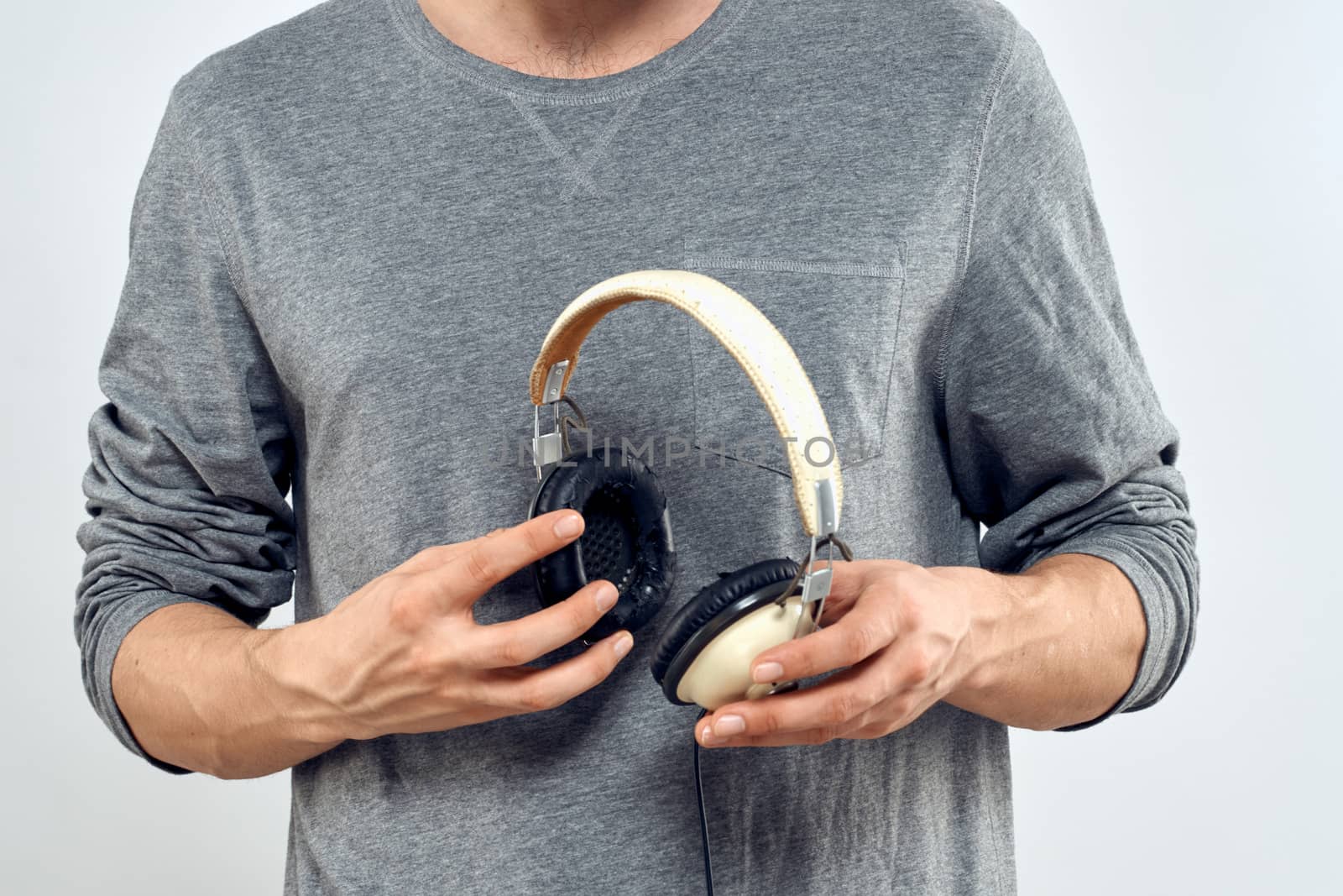 Man holding headphones in the hands of a man lifestyle modern style technology cropped view by SHOTPRIME