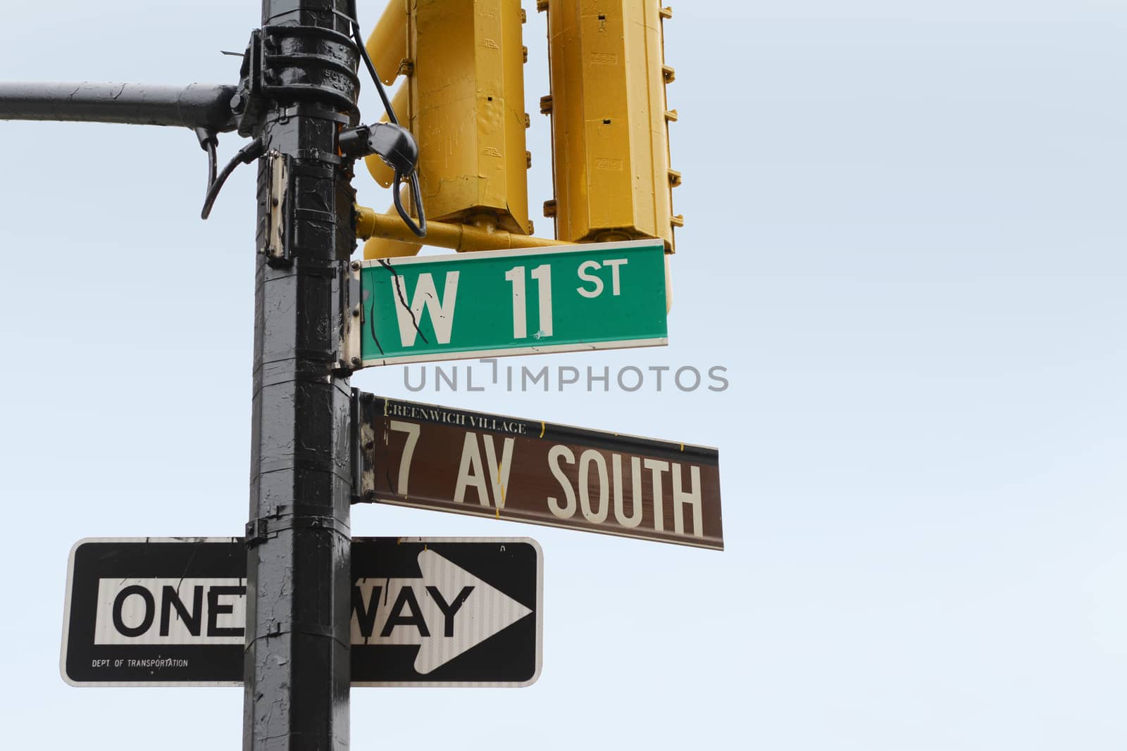 Street signs on the corner of 7th Ave South and West 11th Street in Greenwich Village, New York City; copy space on blue sky