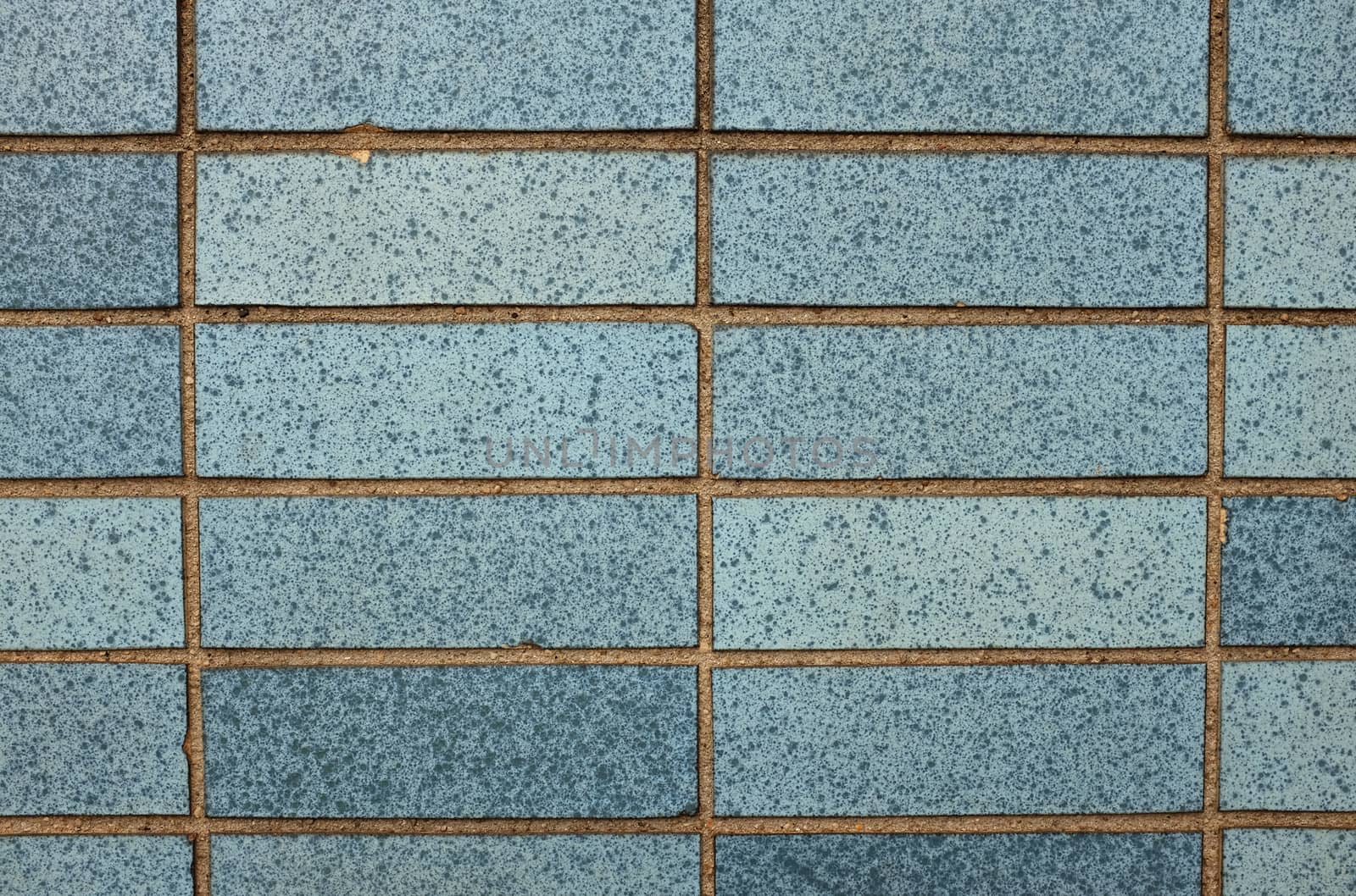 Speckled blue tiles on a wall as an abstract background texture 