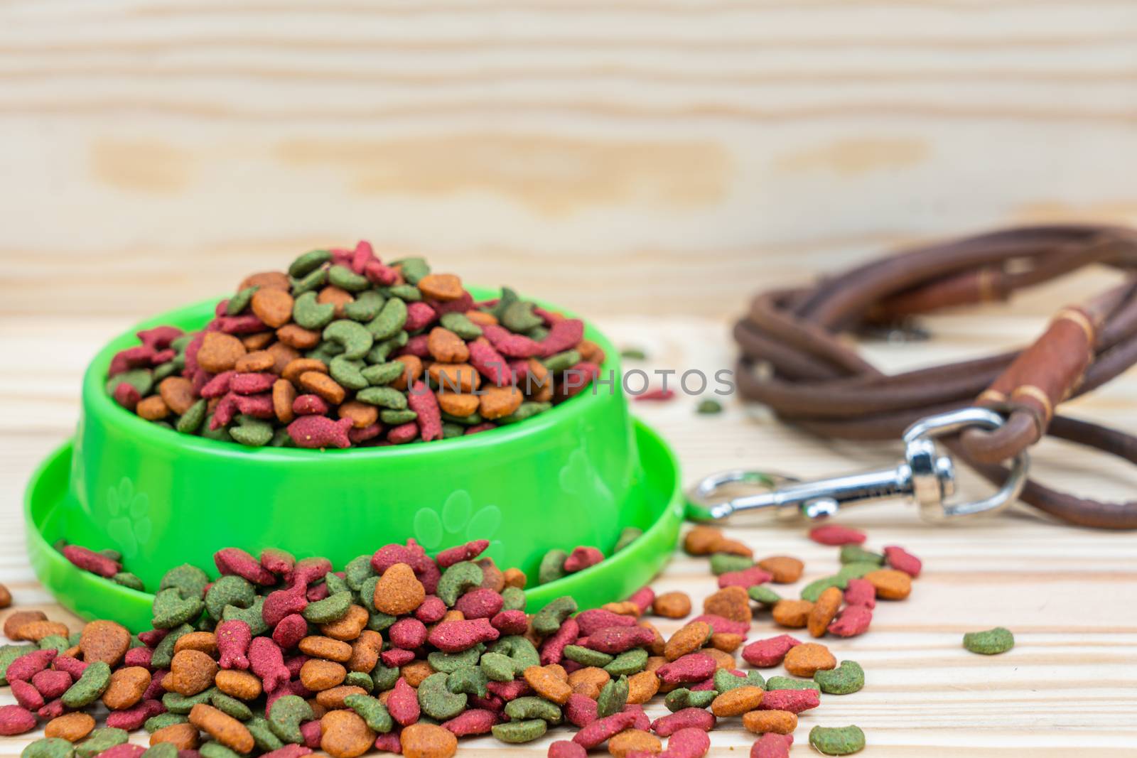 Pet food with leashes on wooden background