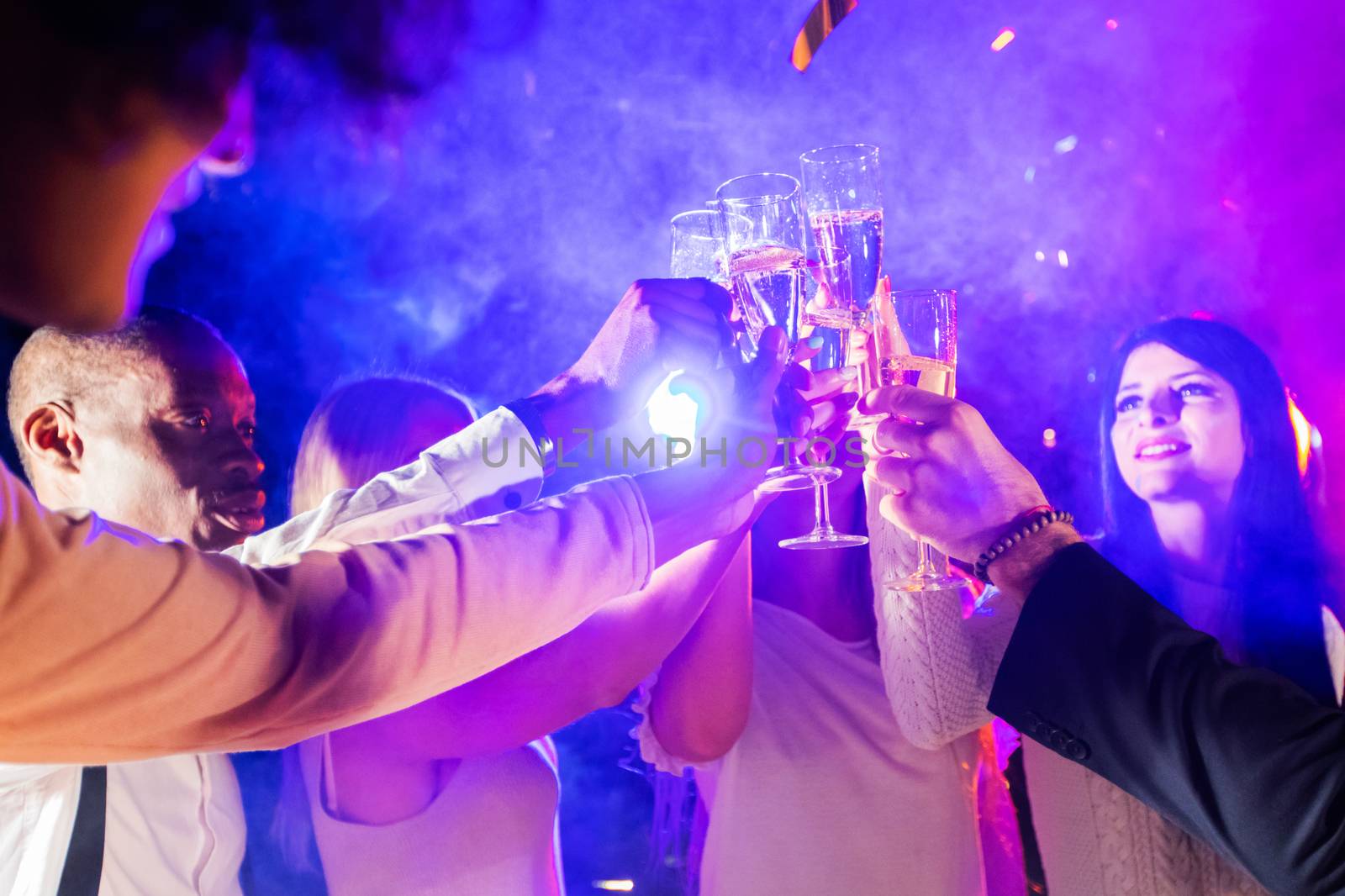 New year celebration party, holidays, nightlife and people concept - smiling friends clink glasses of champagne in night club