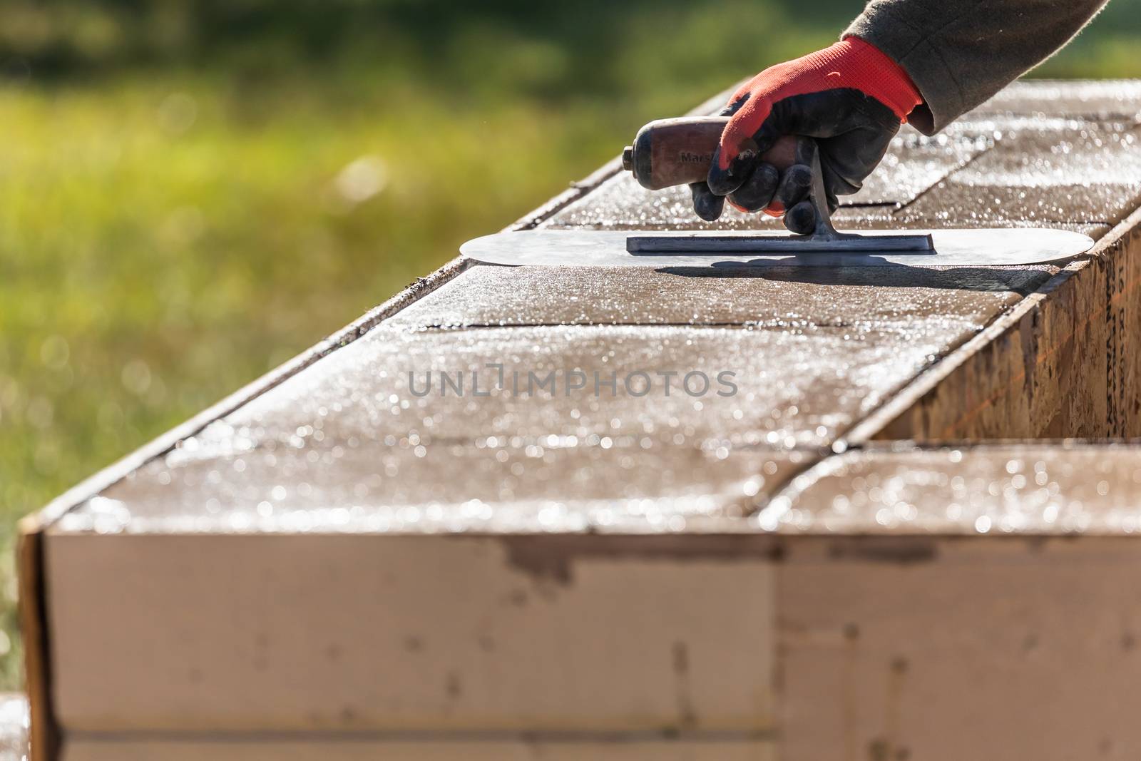 Construction Worker Using Trowel On Wet Cement Forming Coping Ar by Feverpitched