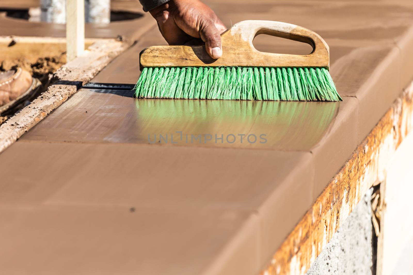 Construction Worker Using Brush On Wet Cement Forming Coping Aro by Feverpitched