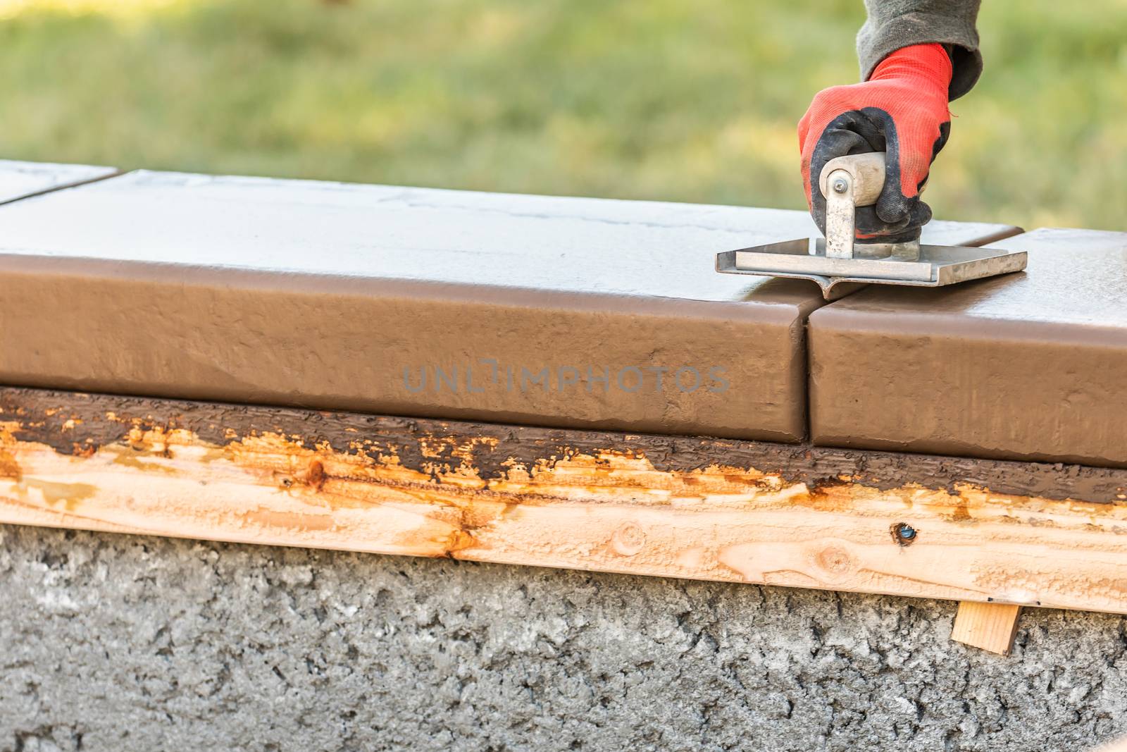 Construction Worker Using Hand Groover On Wet Cement Forming Coping Around New Pool.