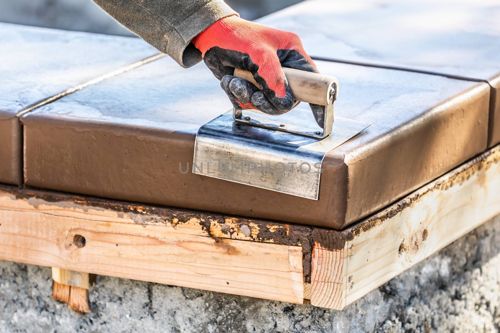 Construction Worker Using Stainless Steel Edger On Wet Cement Fo by Feverpitched