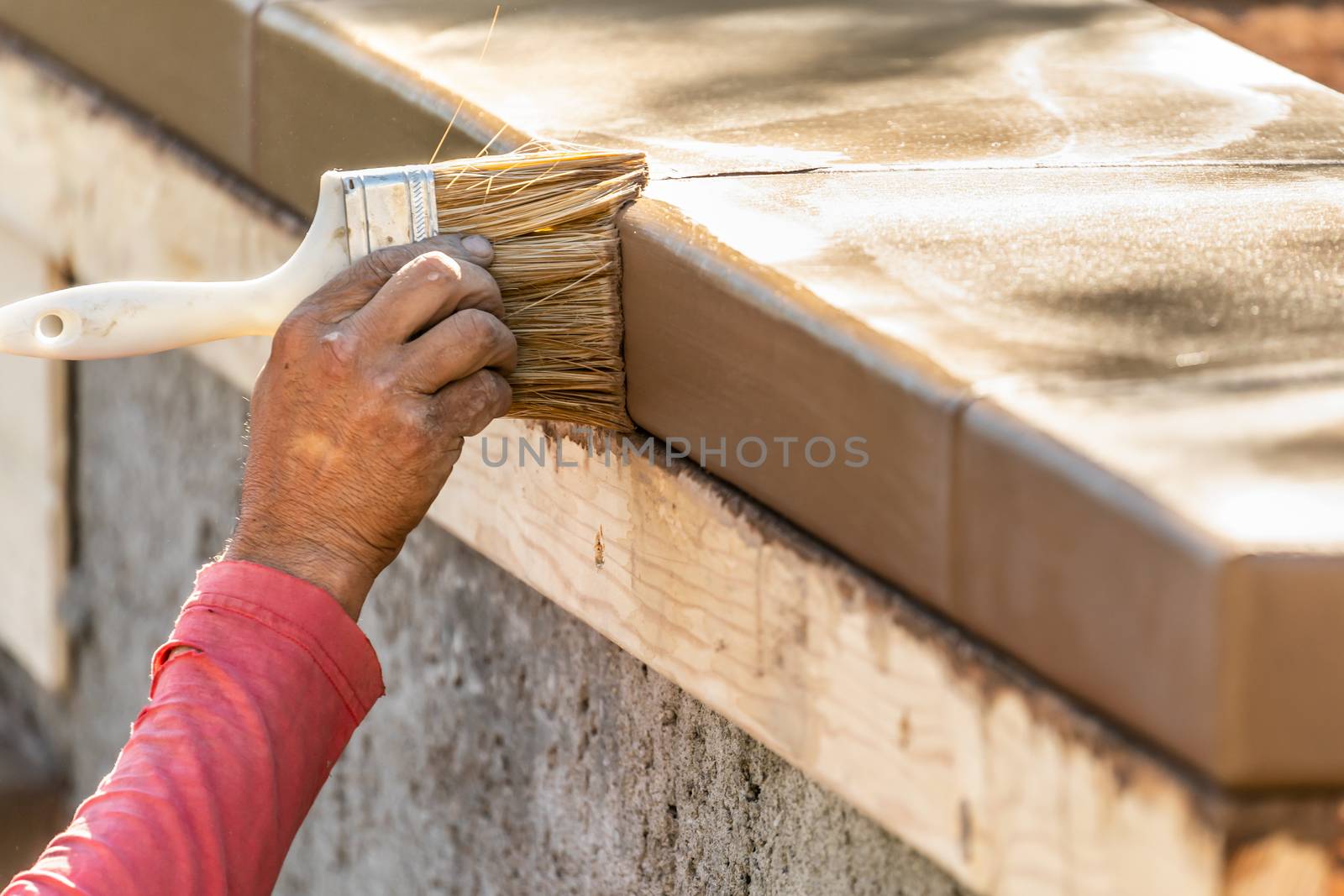 Construction Worker Using Brush On Wet Cement Forming Coping Aro by Feverpitched