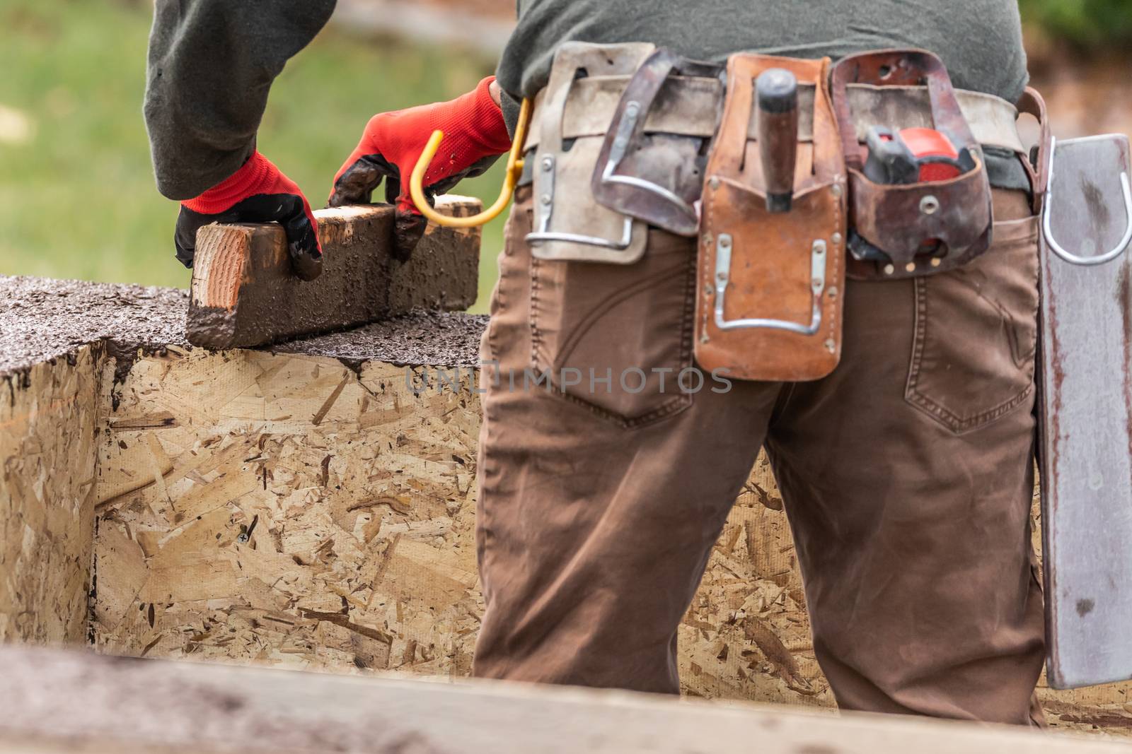 Construction Worker Leveling Wet Cement Into Wood Framing by Feverpitched