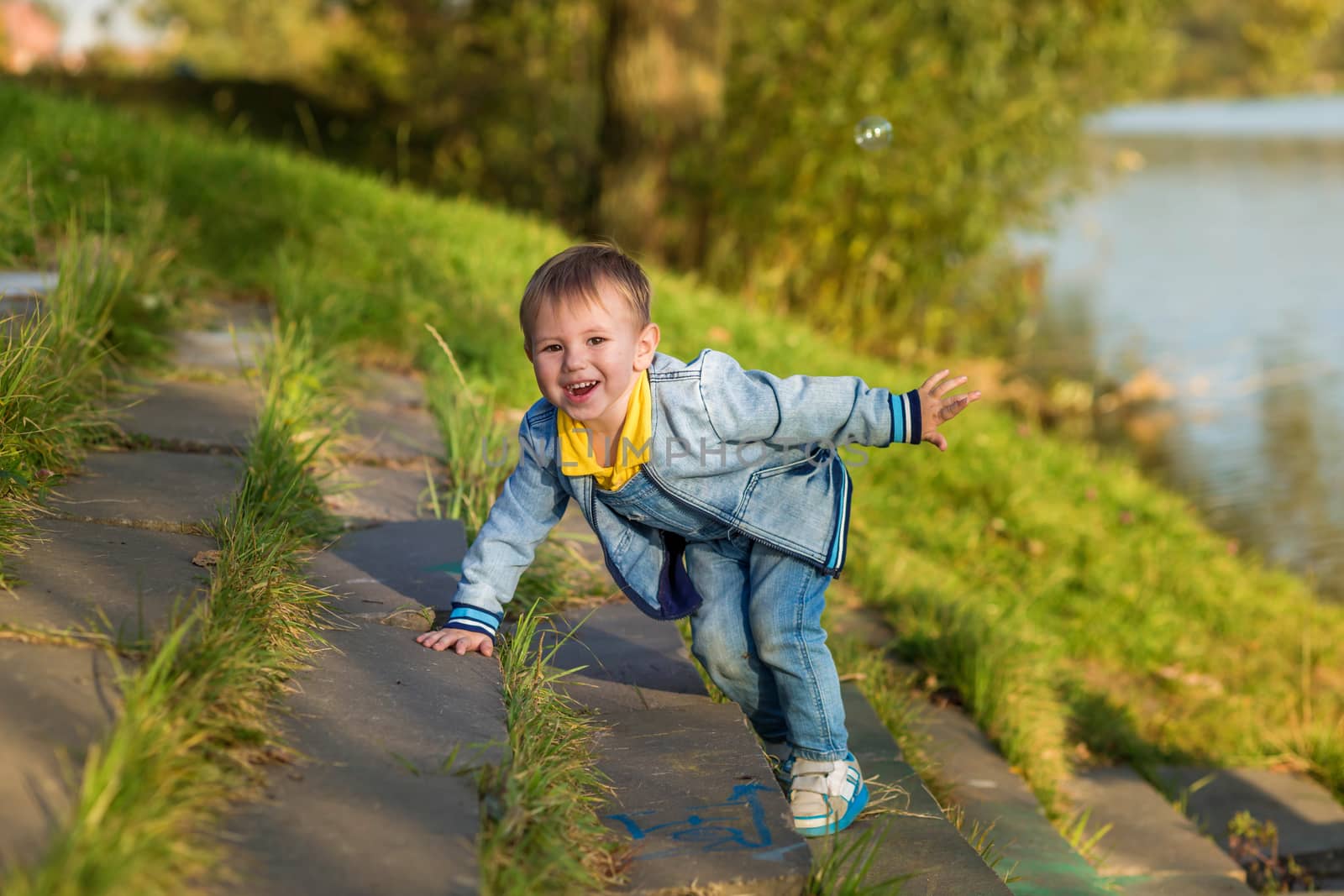 A little boy goes down the stairs in the public park one summer evening.