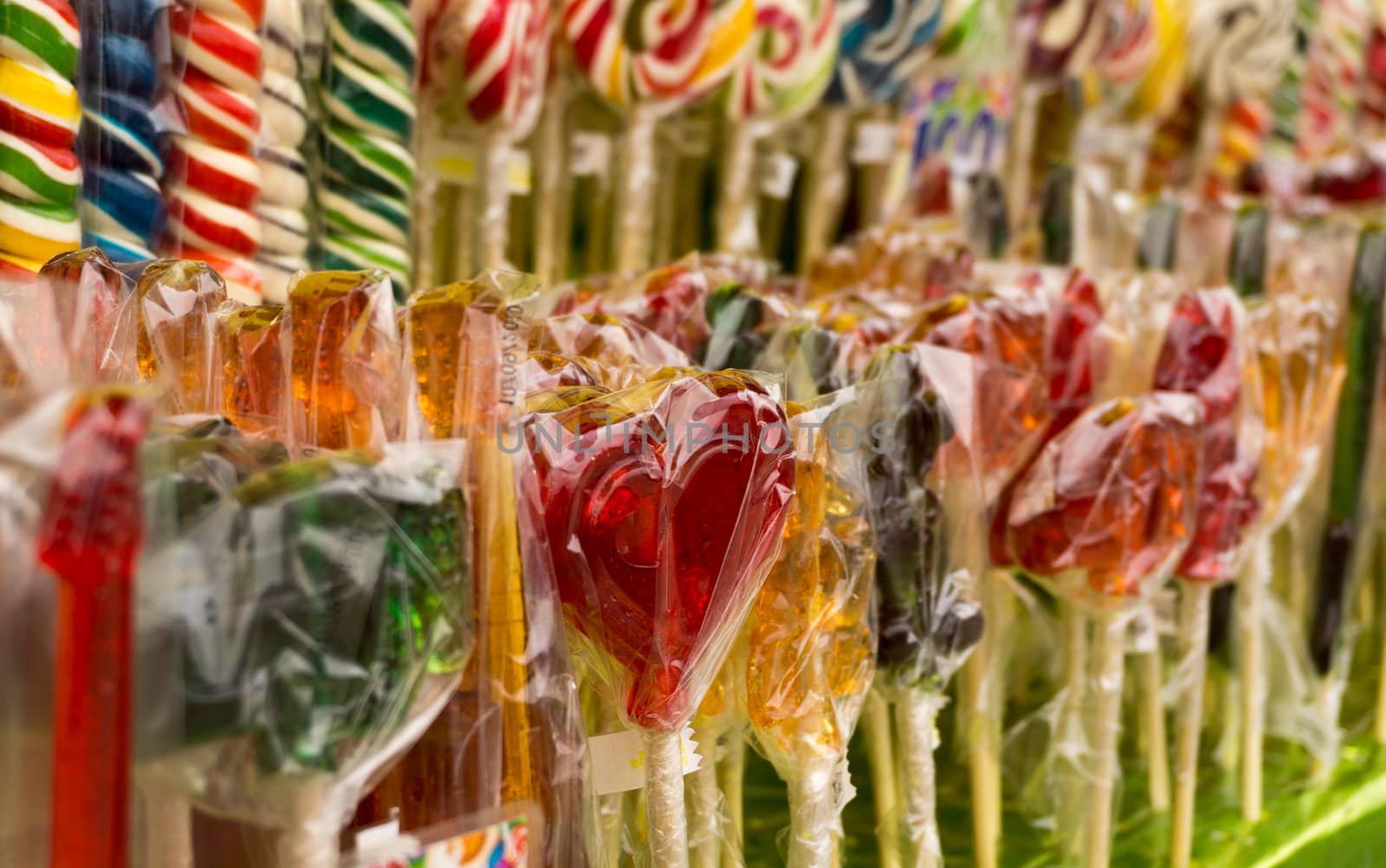 Counter with multicolored sweet lollipops of different shapes