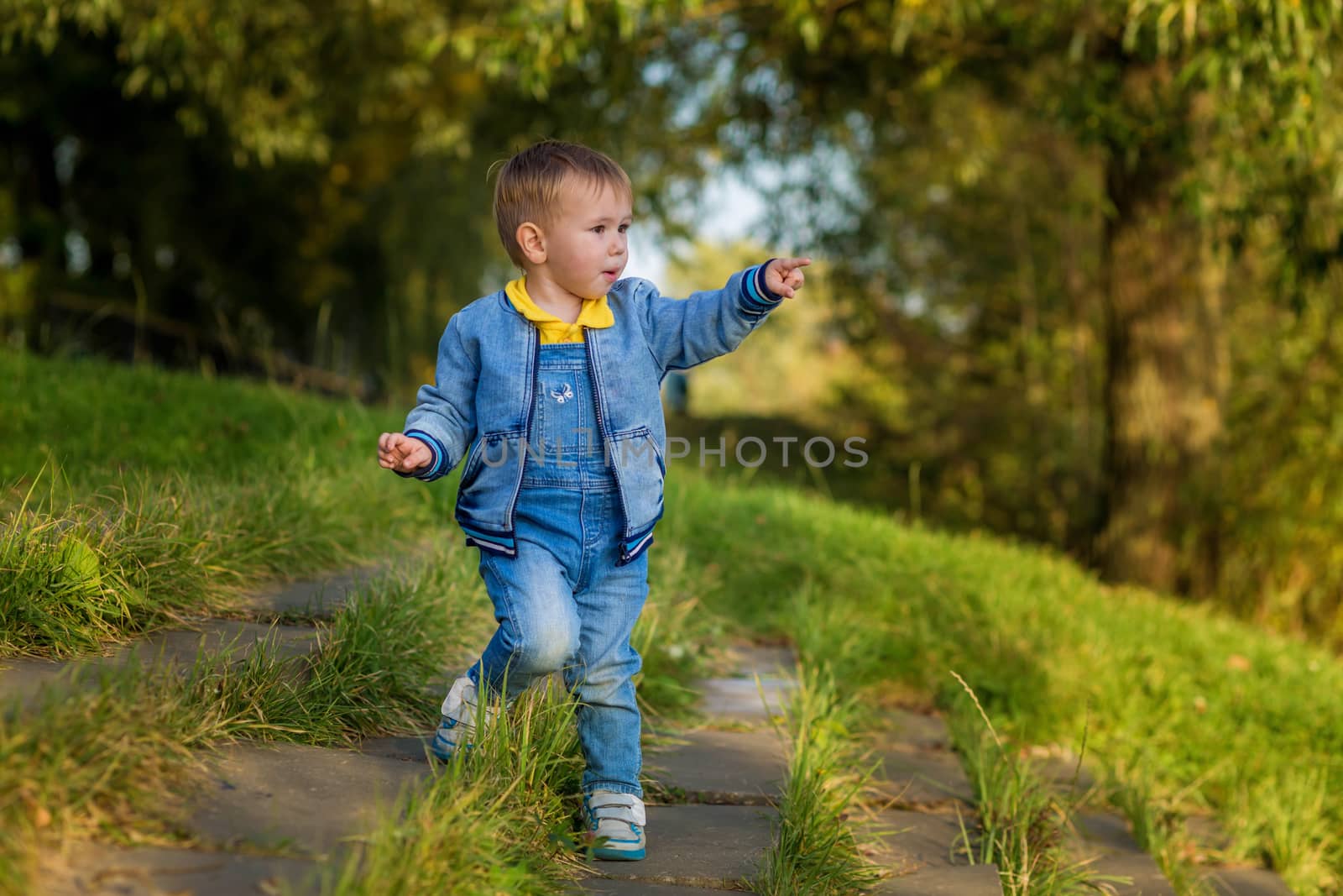 A little boy goes down the stairs in the public park one summer evening.