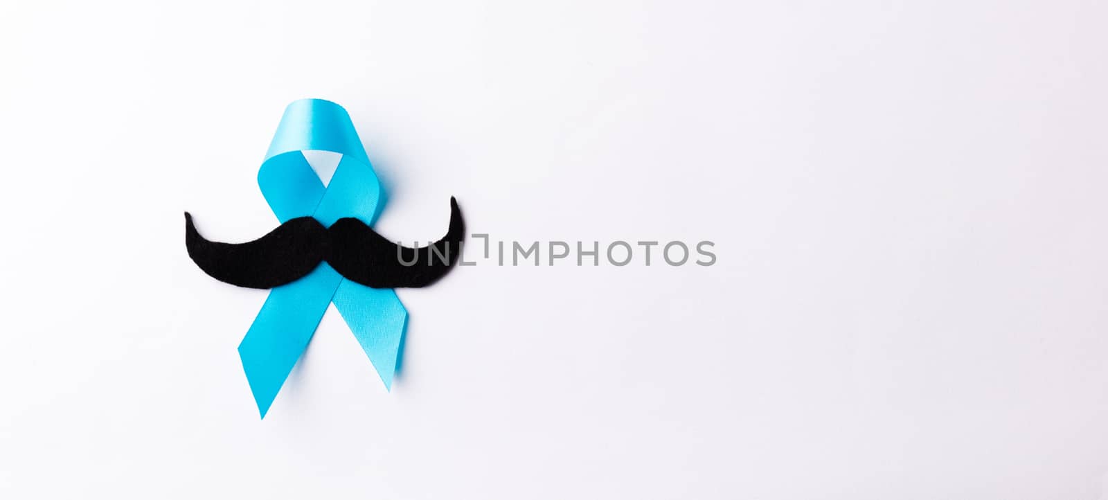 Black mustache paper and light blue ribbon, studio shot isolated on white background, Prostate cancer awareness month, Fathers day, minimal November moustache concept