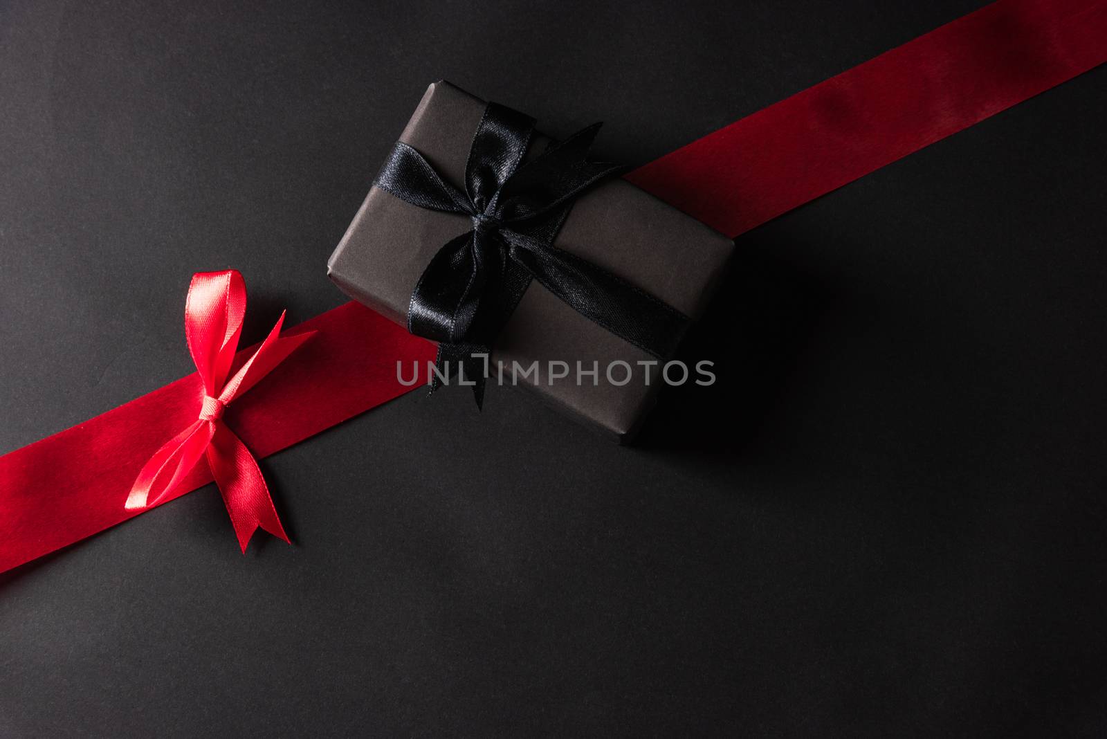 gift box wrapped black paper and black bow ribbon press by Sorapop