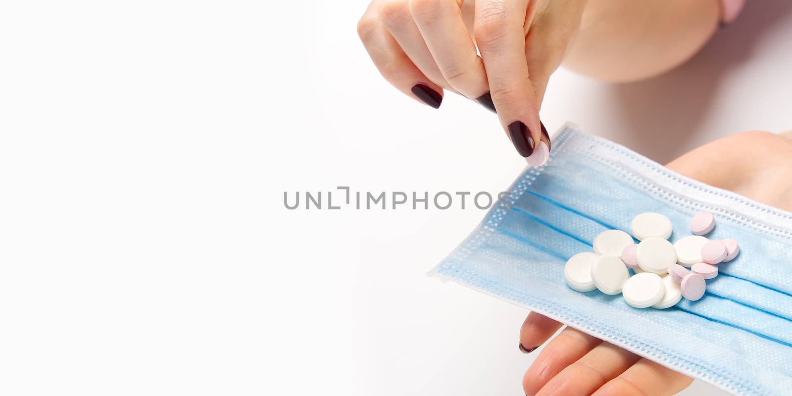 concept covid vaccine pills. COVID-19. Medical mask on a hand with white background. Medicine pills or Vaccine against the virus. Hand holds medical face mask and white pills.