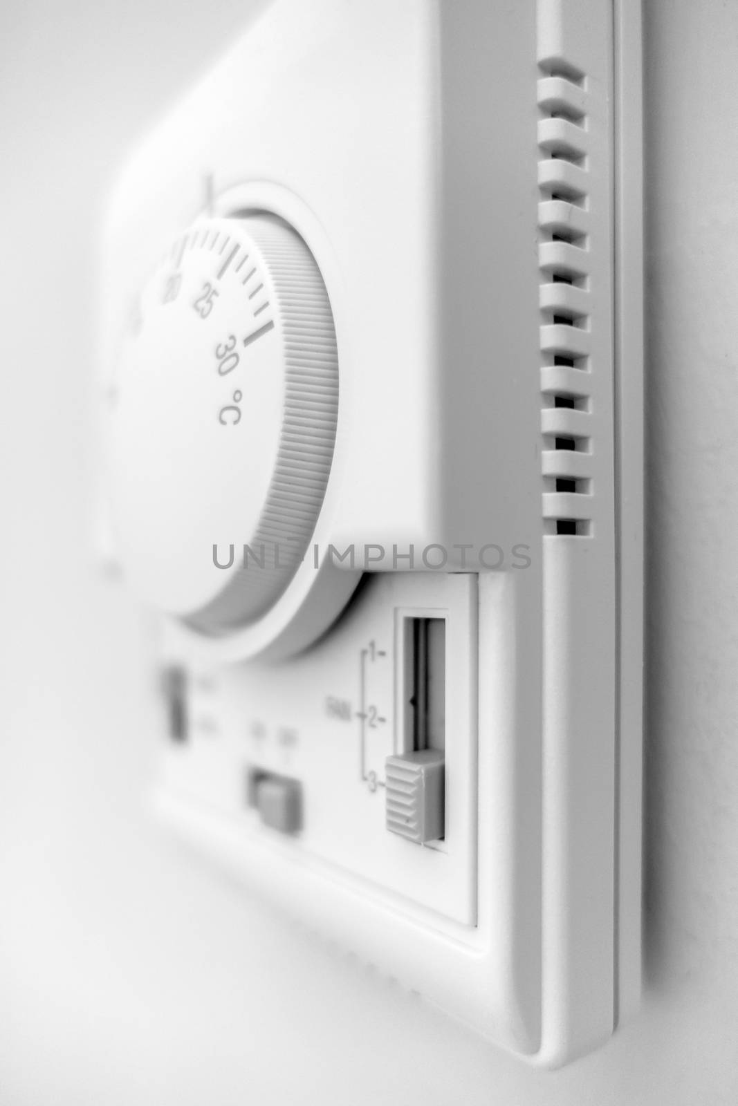 Hand adjusting thermostat. hand turning on thermostat climate control. Defocused blurry background.