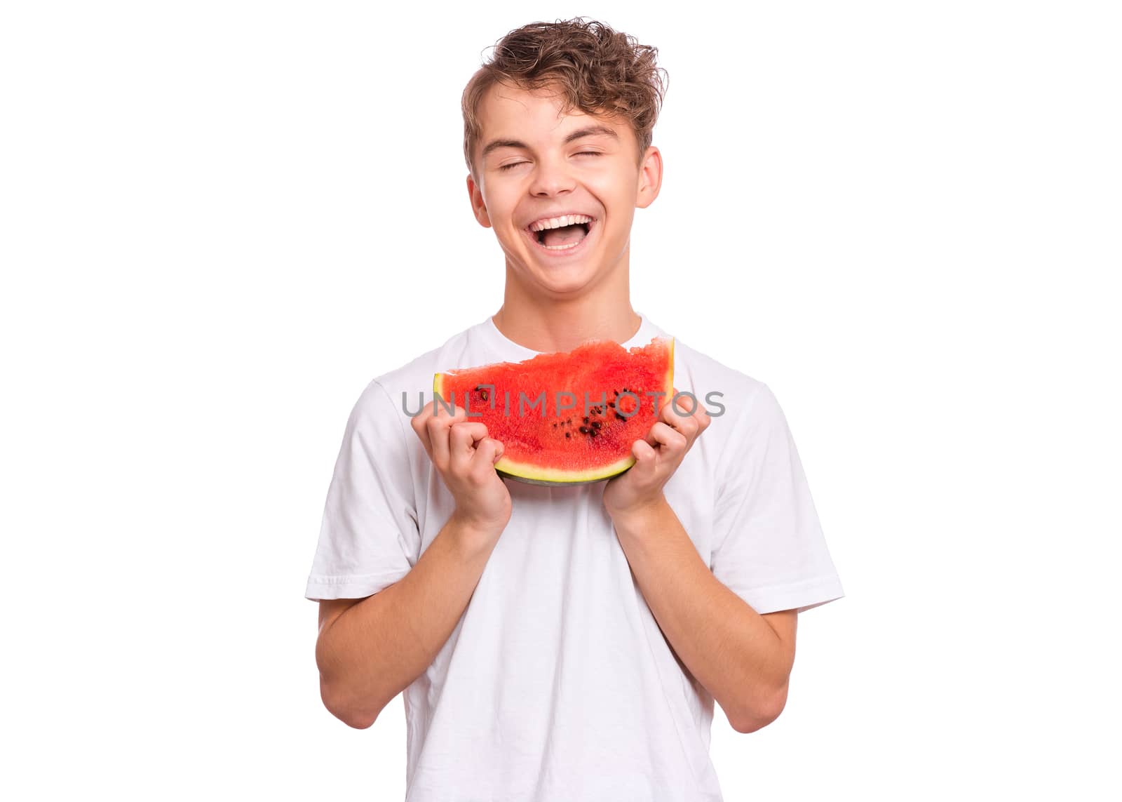 Portrait of teen boy eating ripe juicy watermelon and smiling.