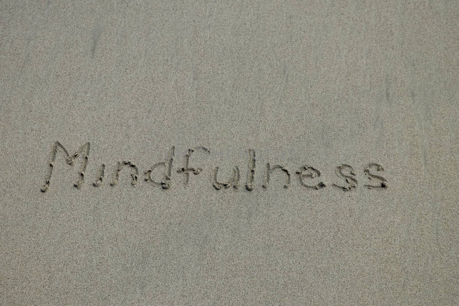 mindfulness concept, mindful living, text written on the sand of beach by Sanatana2008
