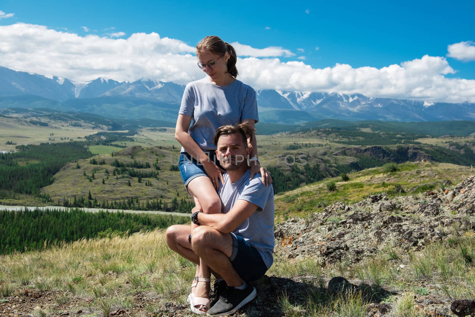 Loving couple together on Altai mountain looking at a view