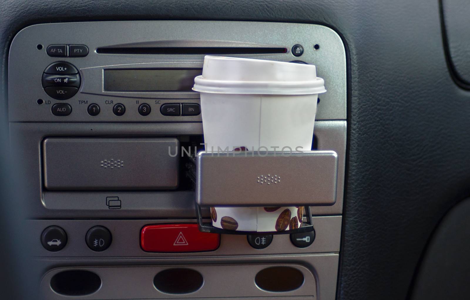 Takeaway paper coffee cup inside car cup holder. by KajaNi