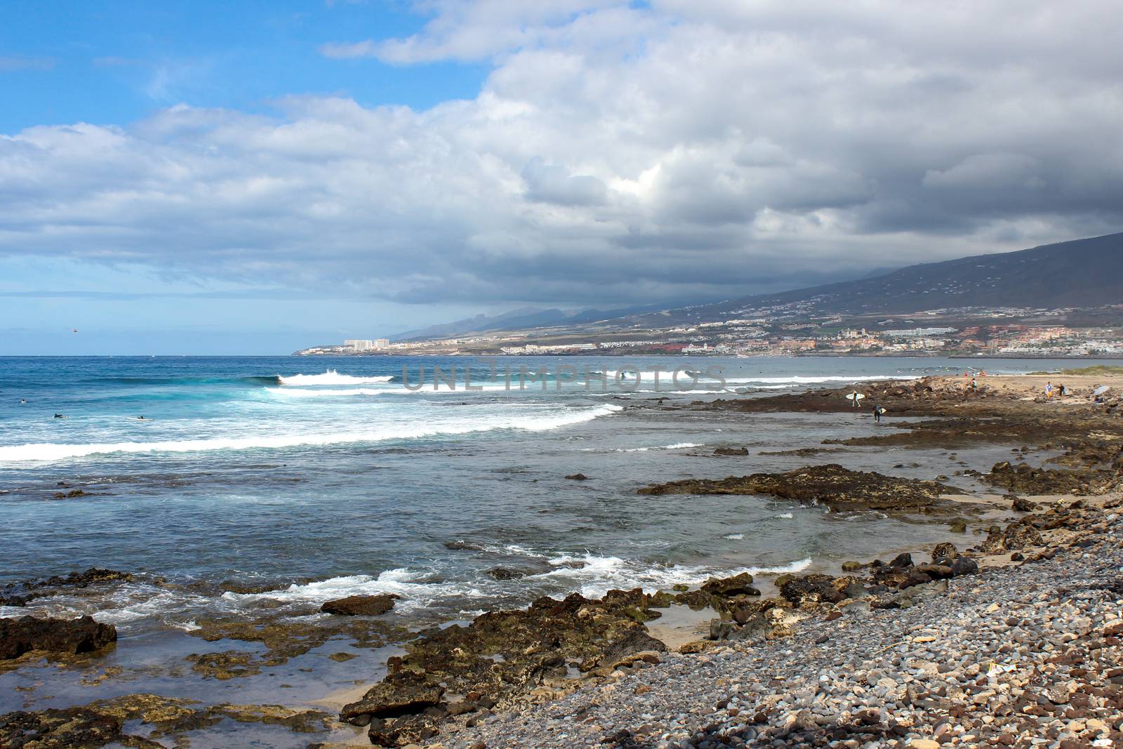 Stony beach at Playa de Las Americas on canary island tenerife with blue water and blue sky