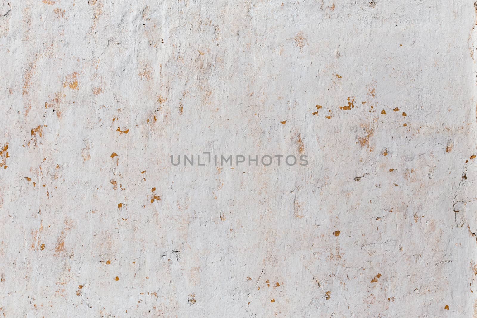 Shabby flat plaster wall with yellow streaks.