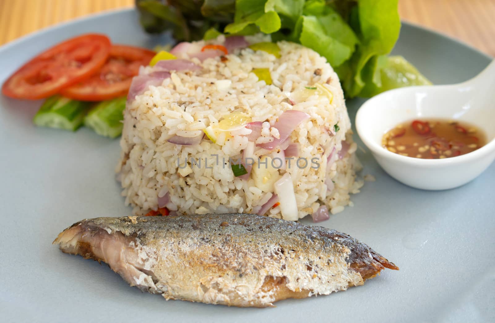 Mackerel fried rice is placed on a plate in a restaurant. by pkproject