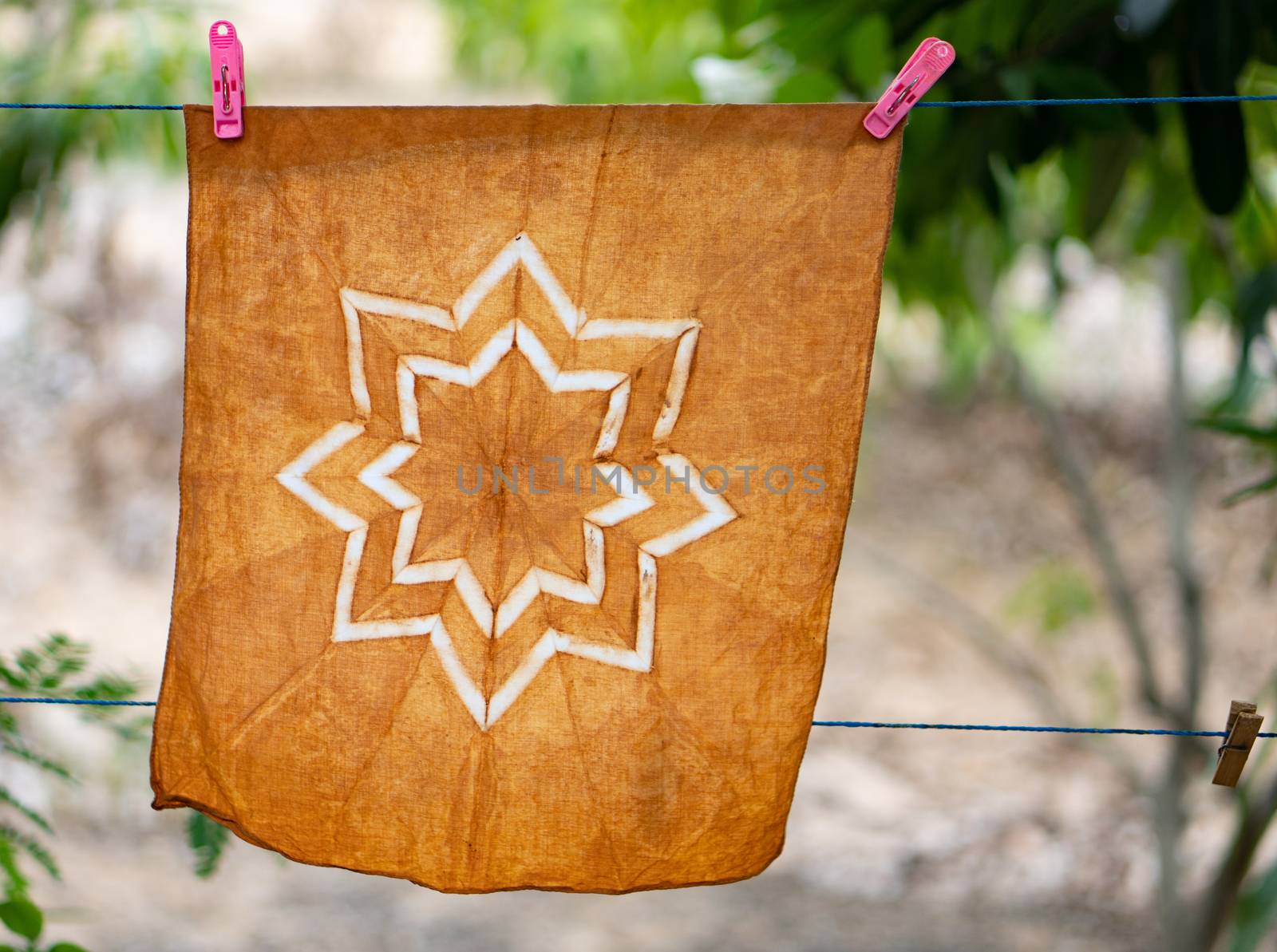 Hand-dyed batik cloth hanging in the outdoor garden.