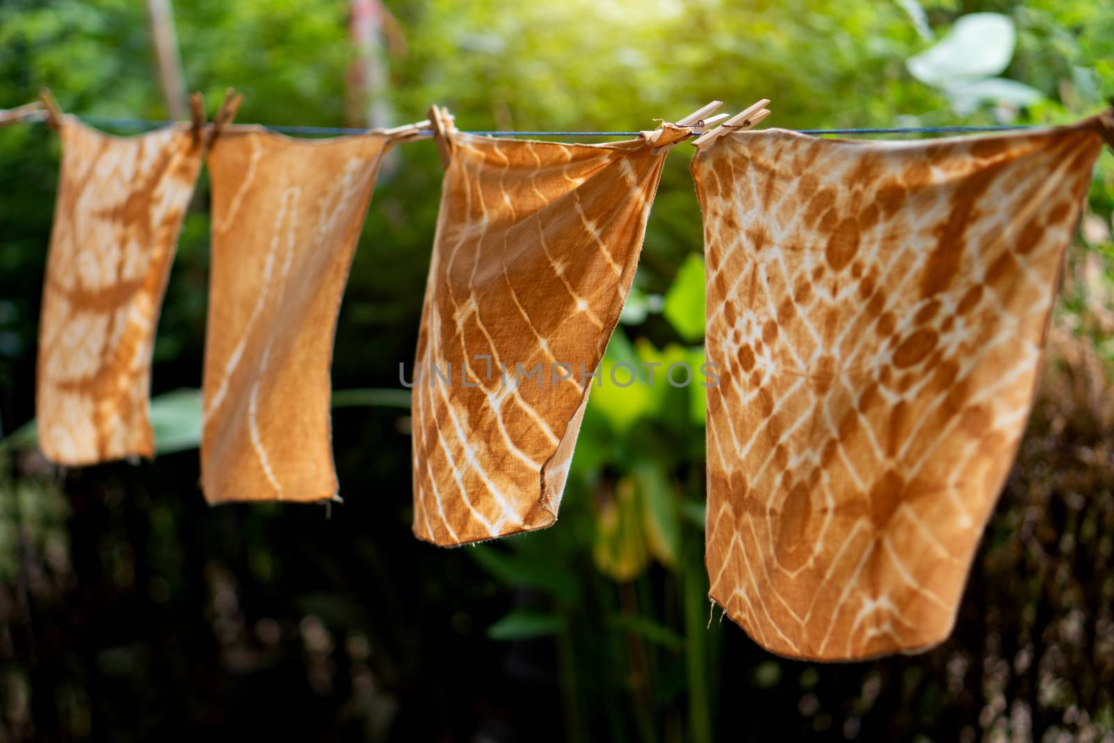 Dyed batik cloth hanging in the outdoor garden. by pkproject