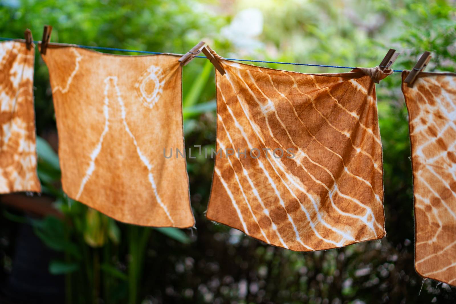 Dyed batik cloth hanging in the outdoor garden. by pkproject