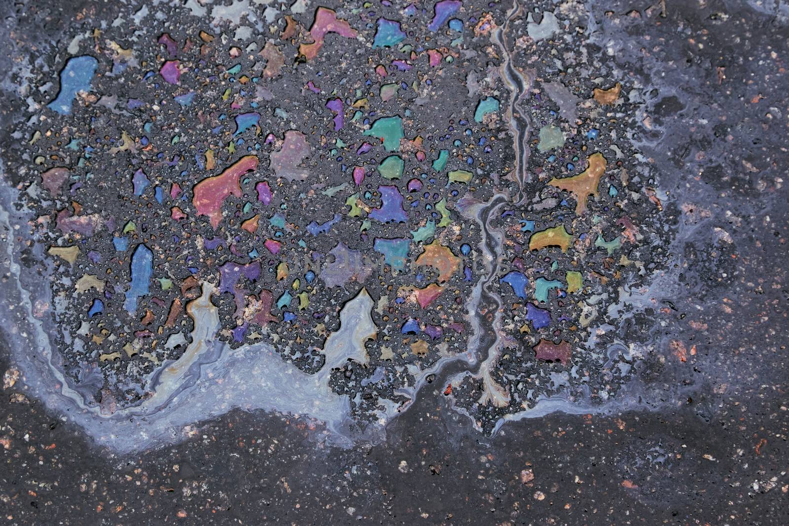 Oil spill on asphalt road background or texture.Environmental pollution concept.