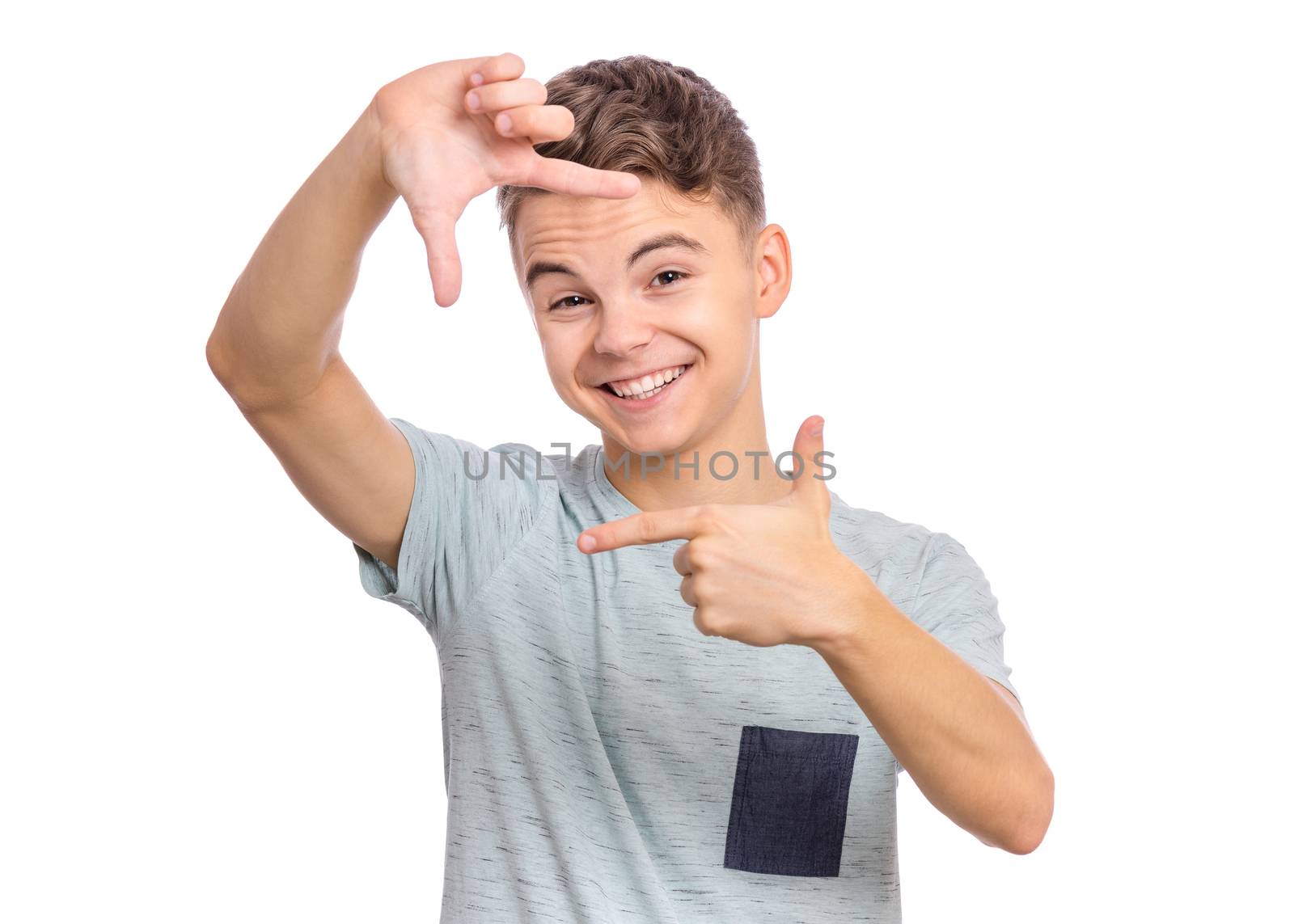 Positive cute teenager making square with his fingers, looking at camera and pleasantly smiling.