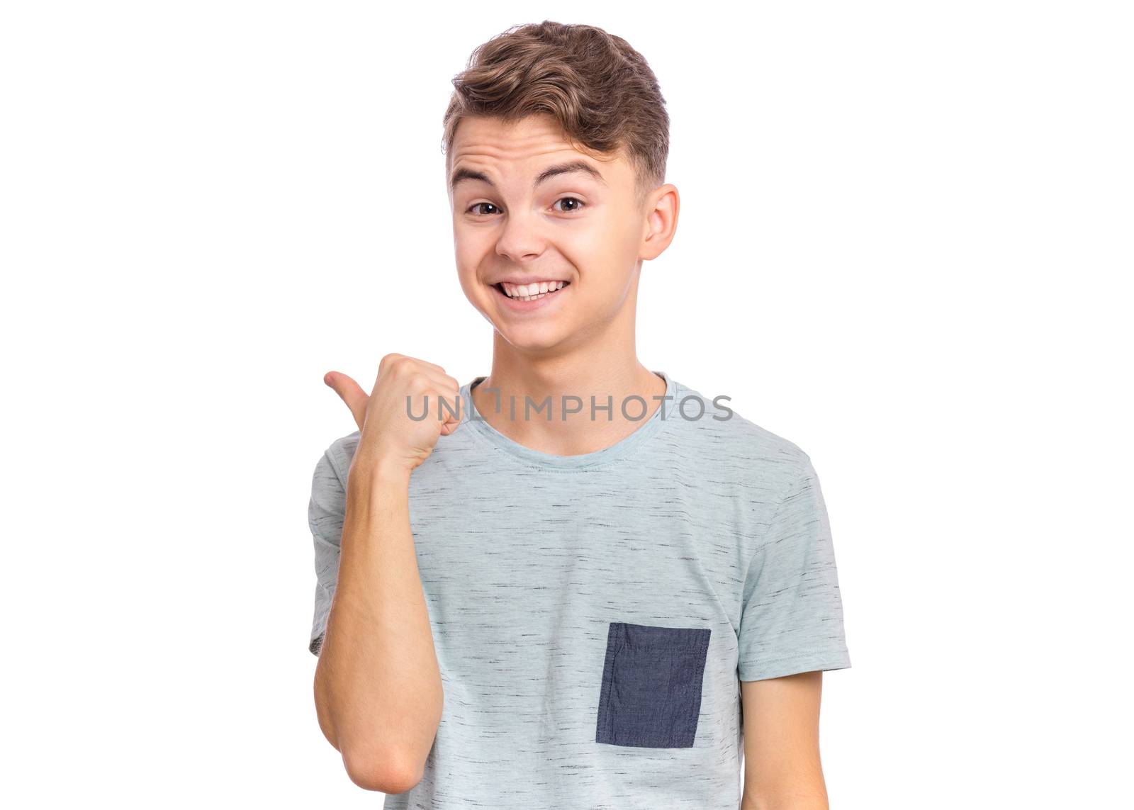 Cute teen boy pointing up, gesturing idea or doing number one gesture.