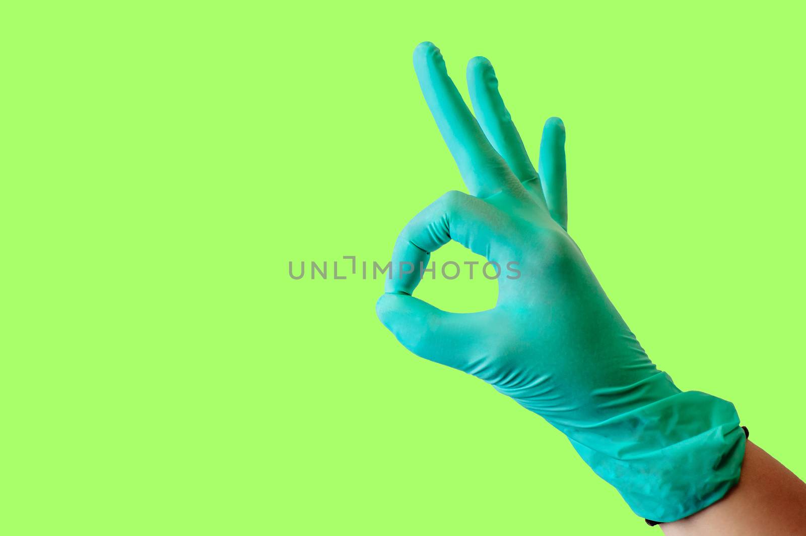 Female hand in blue latex glove makes a gesture resembling a dog with open mouth isolate malachite background. Medical health concept.