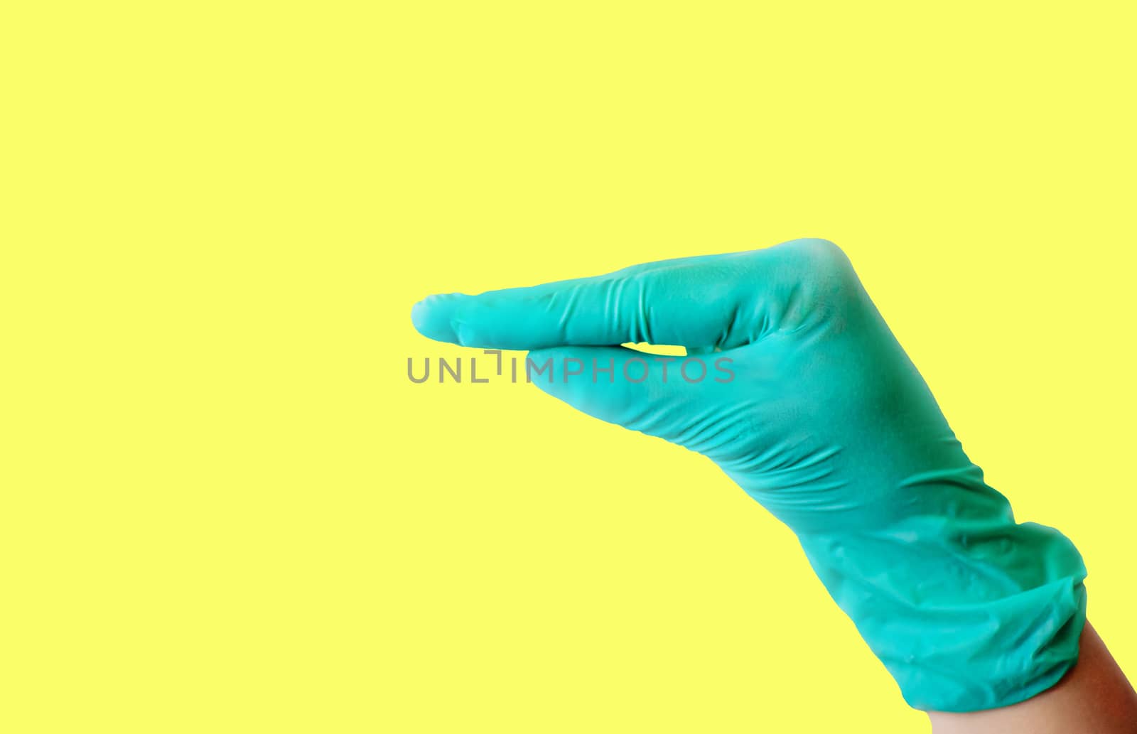 A female hand in a blue latex glove makes a gesture resembling a duck's beak isolate on a light yellow background. Medical health concept. Copy space. by Alla_Morozova93