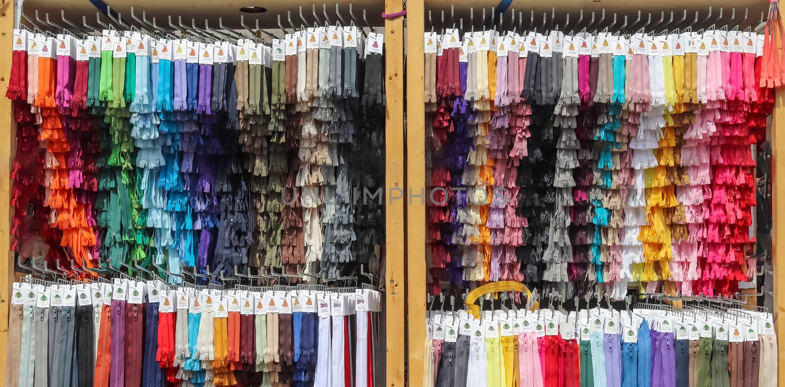 Detailed close up view on samples of zippers in different colors found at a fabrics market.