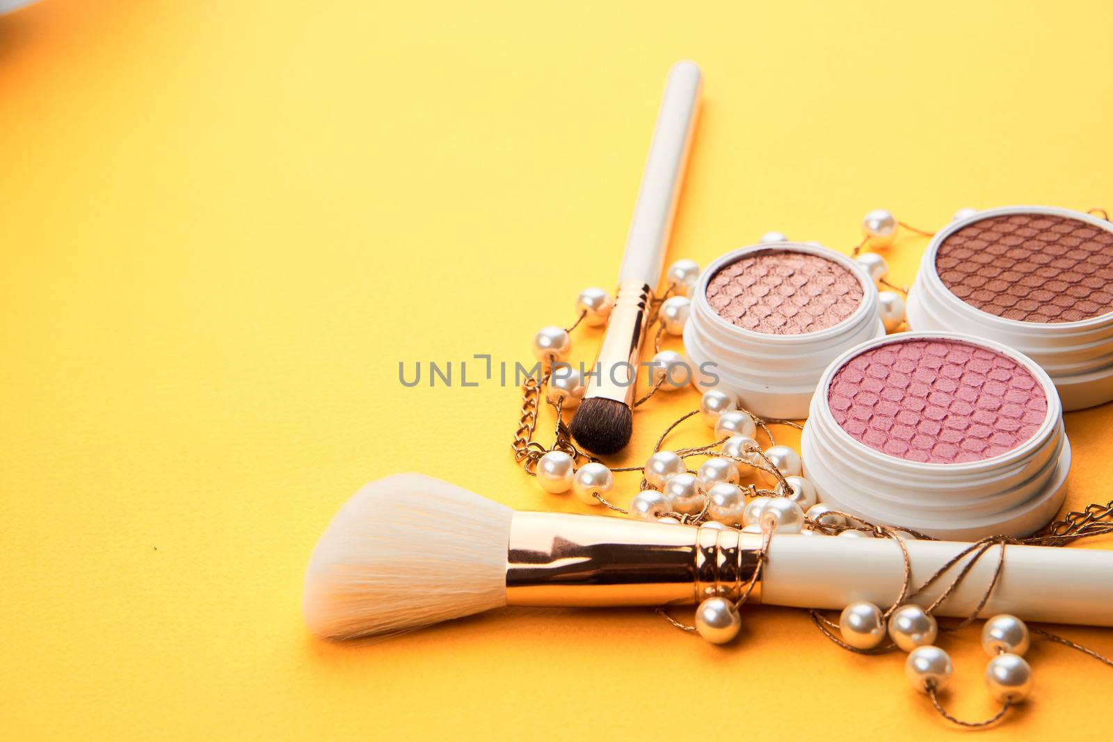 Eyeshadows on a yellow background professional cosmetics makeup brushes soft sponge fashion glasses. High quality photo