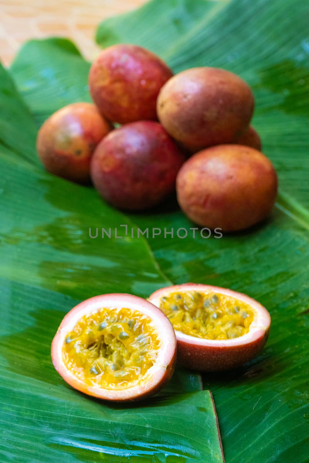 Ripe passion fruit, on a wet banana leaf. Vitamins, fruits, healthy foods.