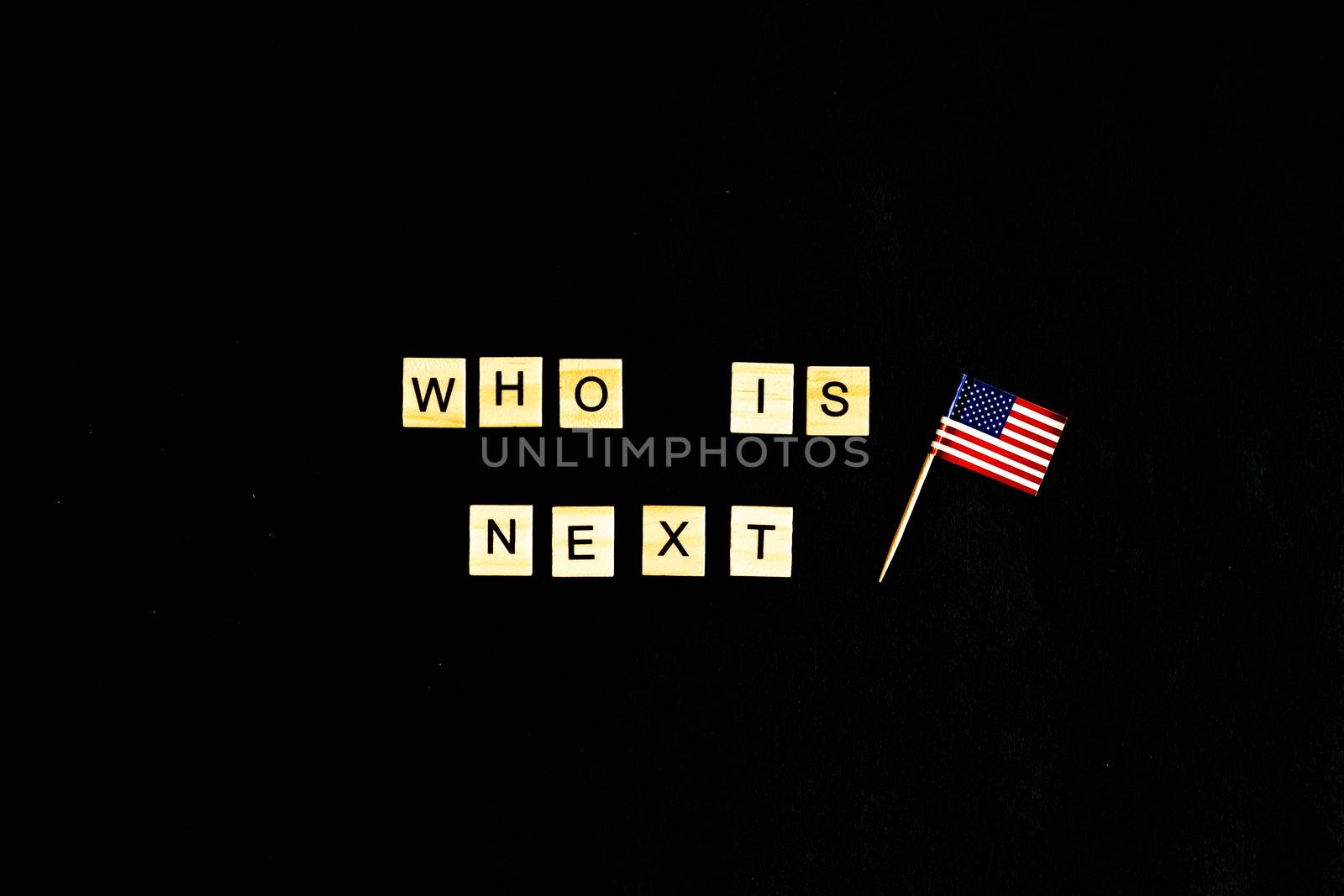 The phrase Who is the next American President - with an American flag in the background. A new election race in the United States. Primary. Candidates. Politics. Government. Force. flatlay, top view.