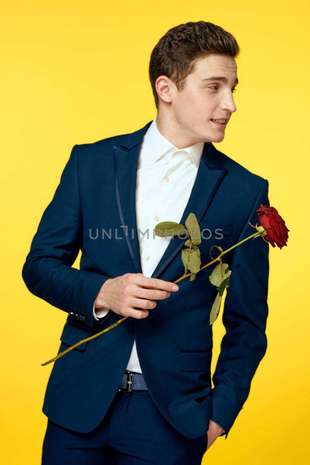 Gentleman in classic suit on yellow background with red rose romance by SHOTPRIME
