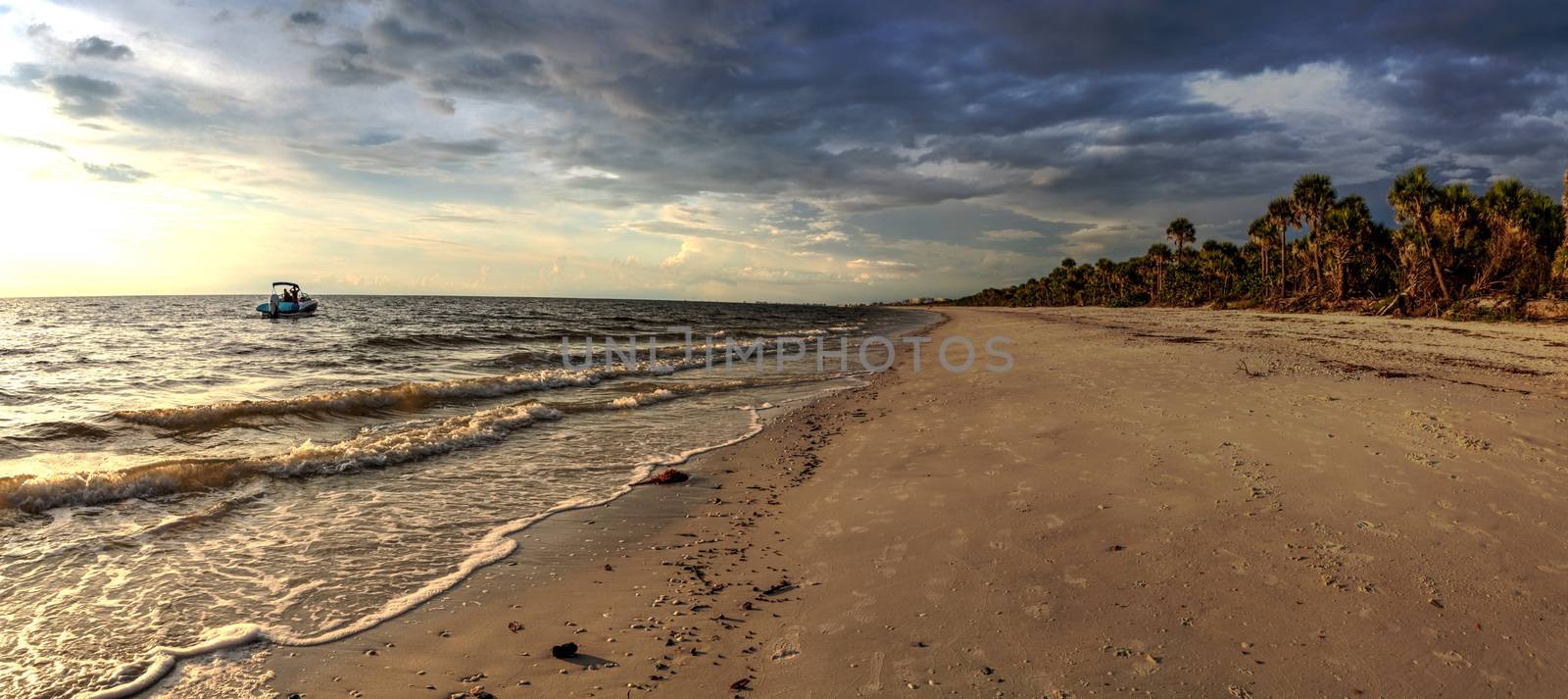 Boat on the waters off Barefoot Beach under dark skies in Bonita Springs, Florida