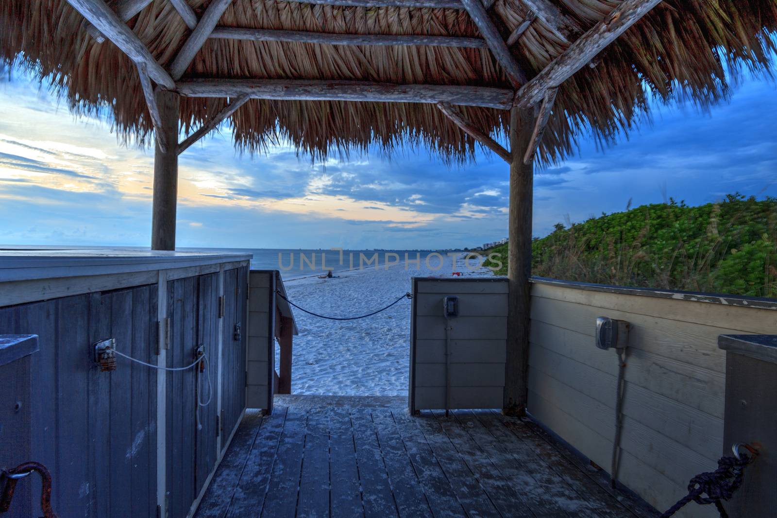 Tiki hut Boardwalk leads down to the white sand of Barefoot Beach in Bonita Springs, Florida