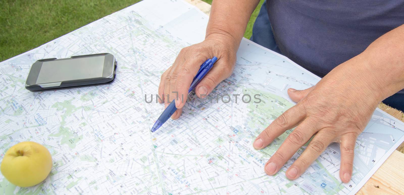 Senior woman looking at a map of Barcelona preparing for a trip, tourism in Europe