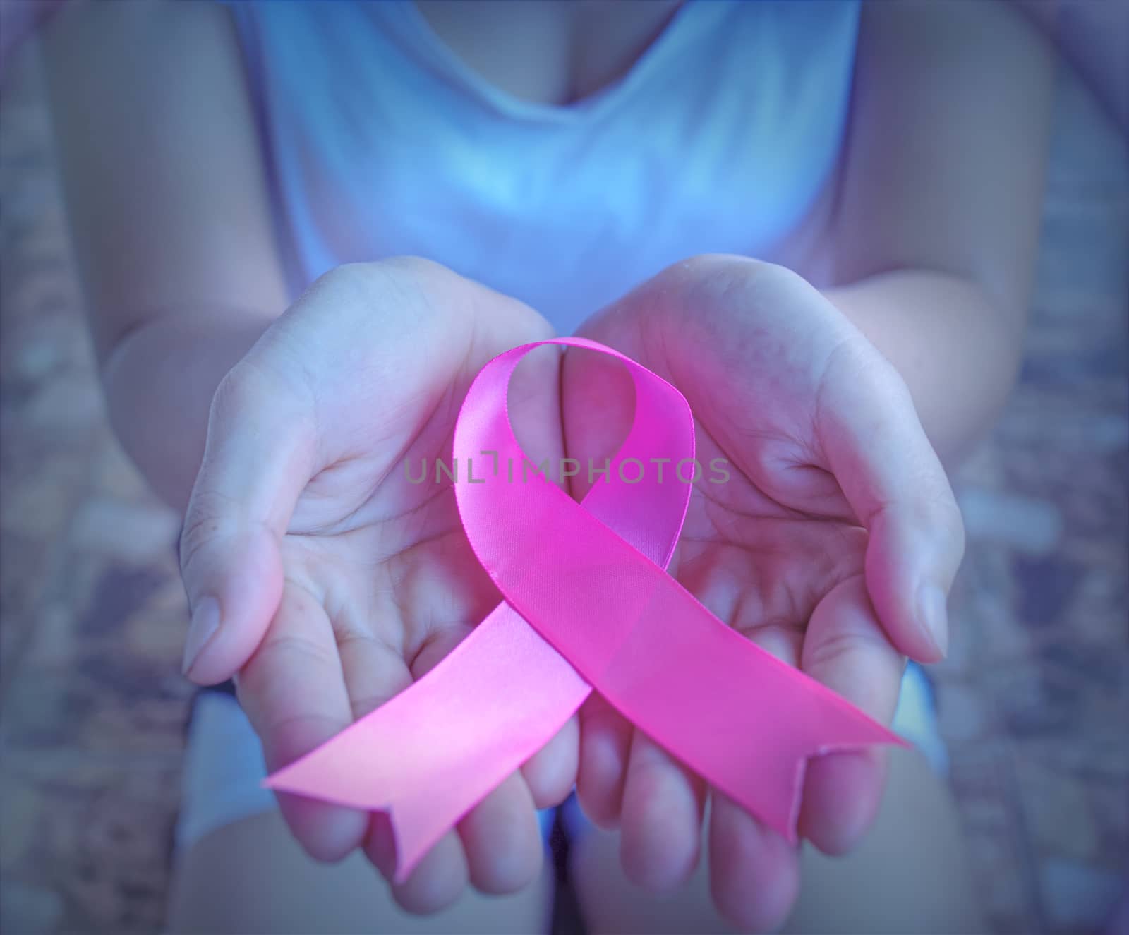 The concept of health care and breast cancer encouraging people around the world of breast cancer patients. Close up holding pink ribbon breast cancer awareness day.