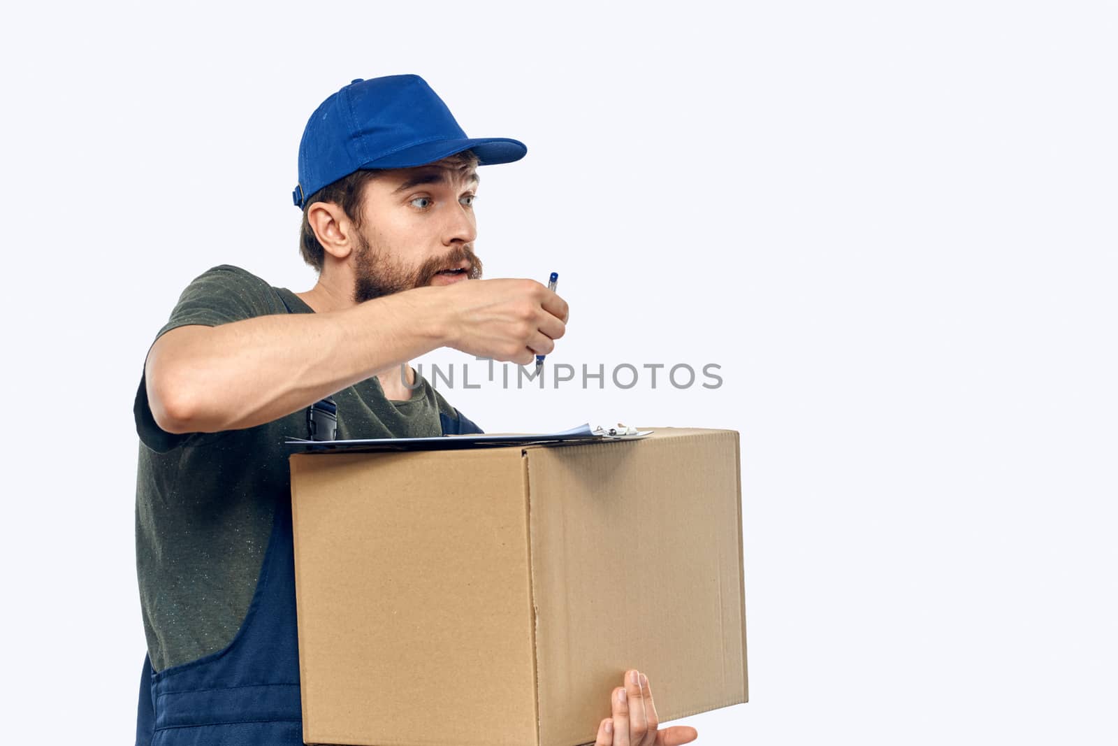 Working male courier with box in hand documents delivery service light background. High quality photo