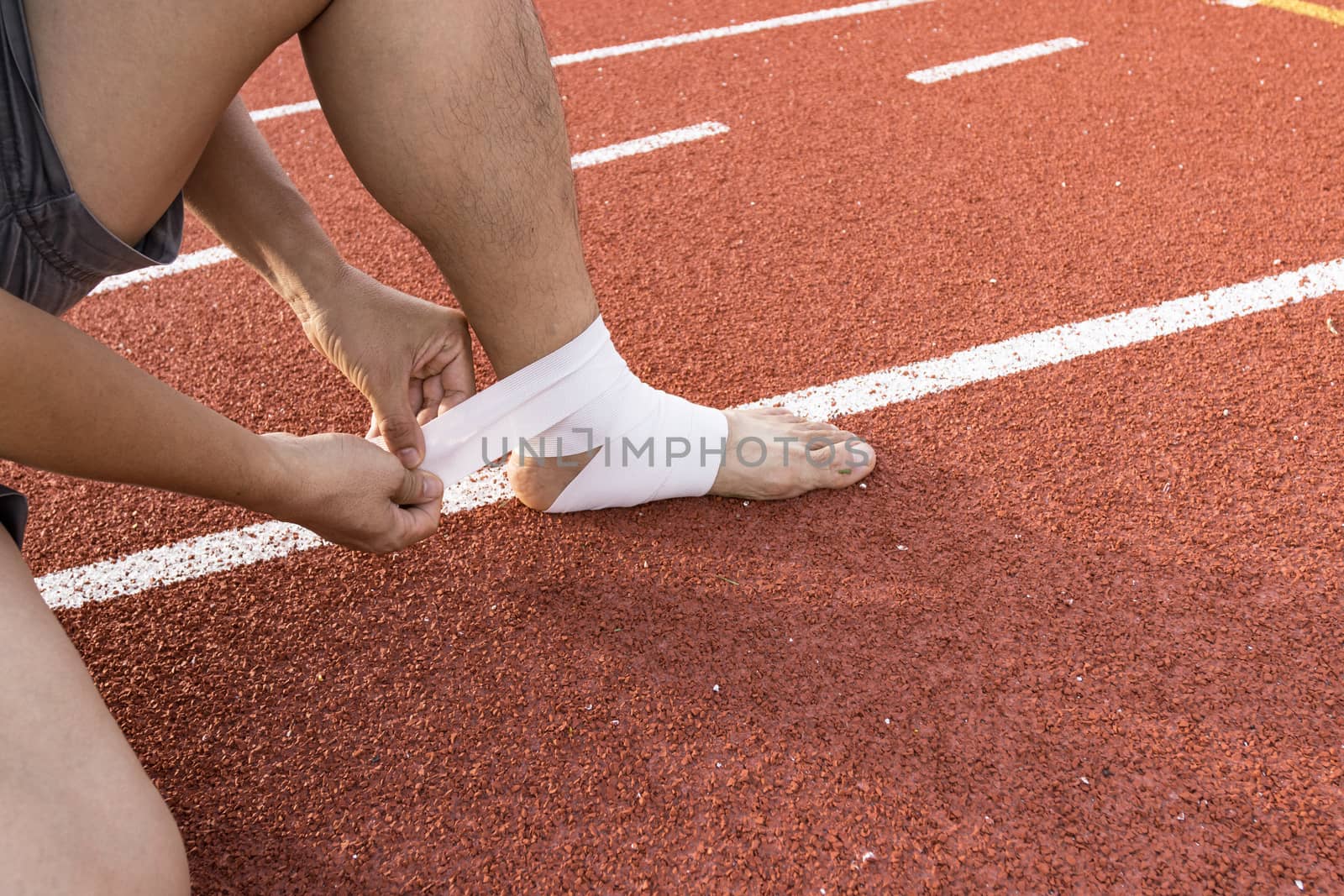 man applying compression bandage onto ankle injury After exercise concept Sports injuries.
