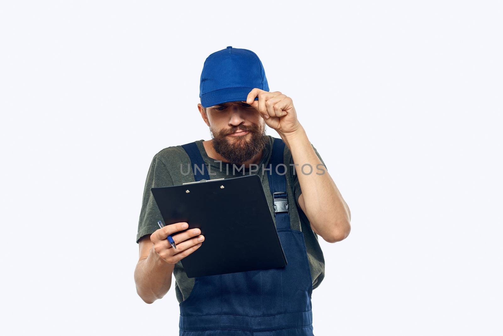 man in working uniform documents delivery loader transportation light background. High quality photo