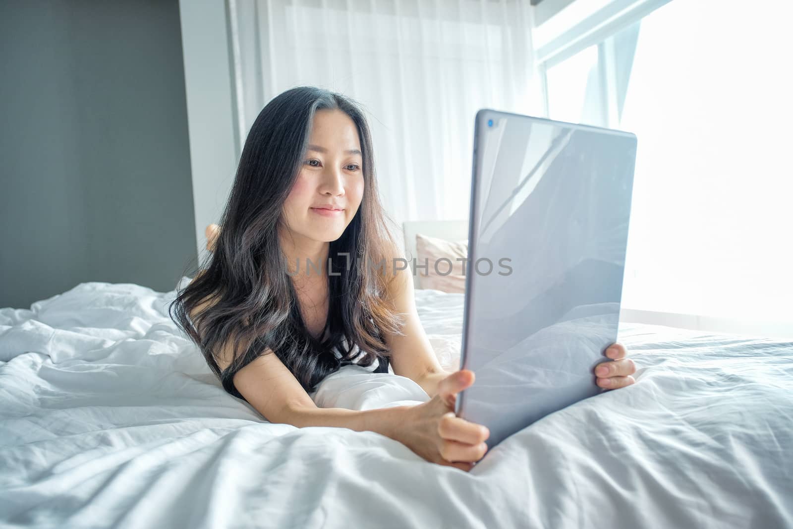 Yound woman using tablet on the bed 