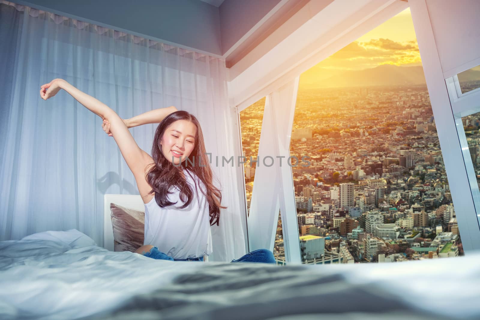 Woman stretch herself out after waking up in the morning  by Surasak