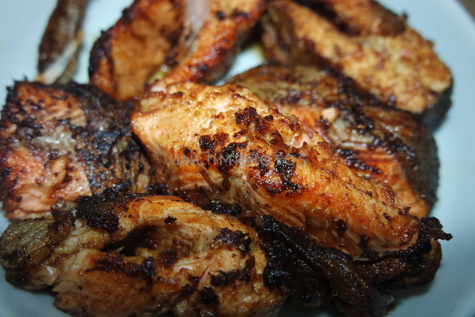 Spicy and crunchy barbecue of fried fish fillet on a white background. Homemade grilled trout fish steaks for health nourishments.